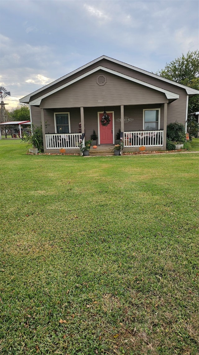 view of front of home with covered porch and a front yard