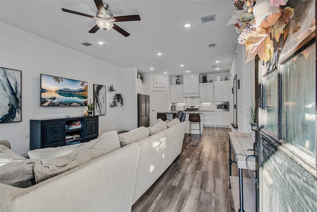 living room with hardwood / wood-style flooring and ceiling fan