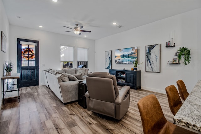 living room with ceiling fan and light hardwood / wood-style flooring