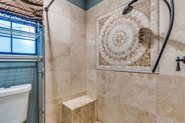 bathroom featuring a tile shower and toilet