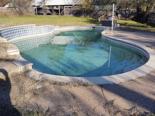 view of swimming pool with a yard