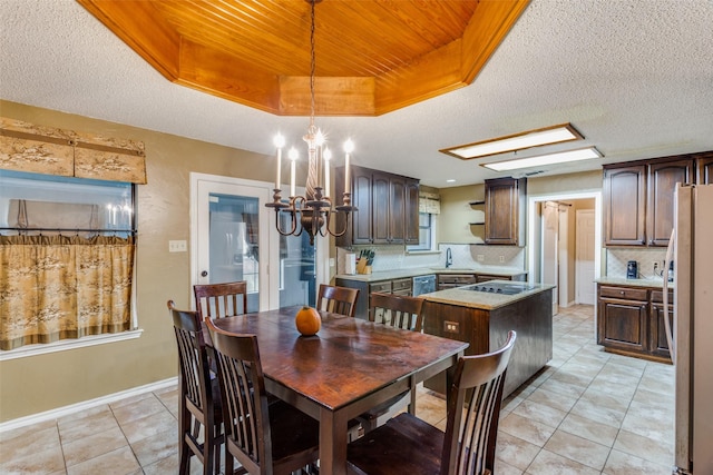 dining room with a chandelier, light tile patterned floors, a textured ceiling, and sink