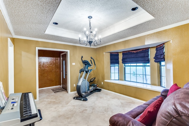 exercise room with a textured ceiling, an inviting chandelier, crown molding, and a tray ceiling