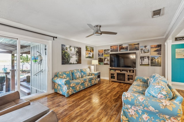 living room featuring ornamental molding, a textured ceiling, hardwood / wood-style flooring, and ceiling fan