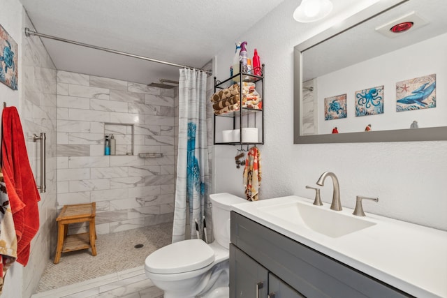 bathroom with tile patterned floors, vanity, a textured ceiling, a shower with shower curtain, and toilet