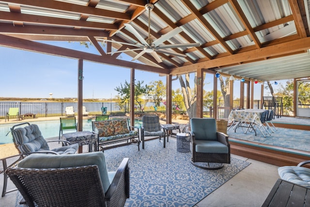 sunroom featuring ceiling fan, a wealth of natural light, and vaulted ceiling with beams