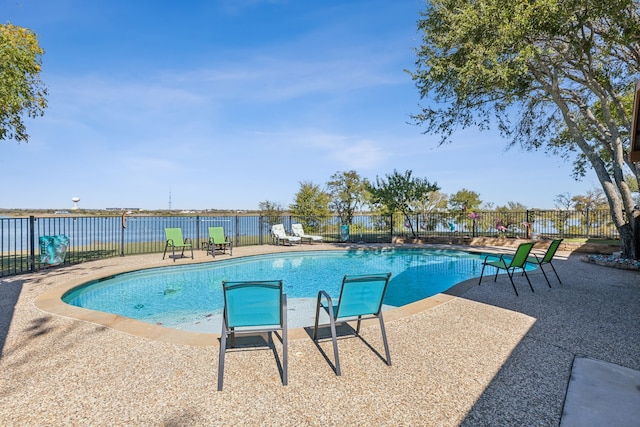 view of pool featuring a water view and a patio area