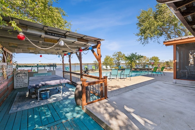 wooden deck with a community pool, a water view, and a patio