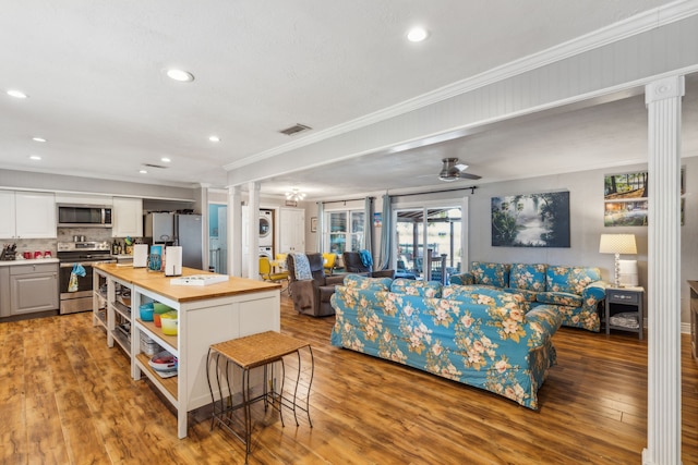 living room with ornamental molding, ceiling fan, hardwood / wood-style flooring, and ornate columns