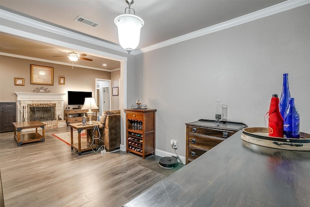 interior space with hardwood / wood-style floors, a stone fireplace, and ornamental molding