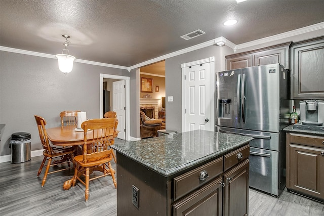 kitchen with a center island, stainless steel refrigerator with ice dispenser, a textured ceiling, dark brown cabinets, and light wood-type flooring