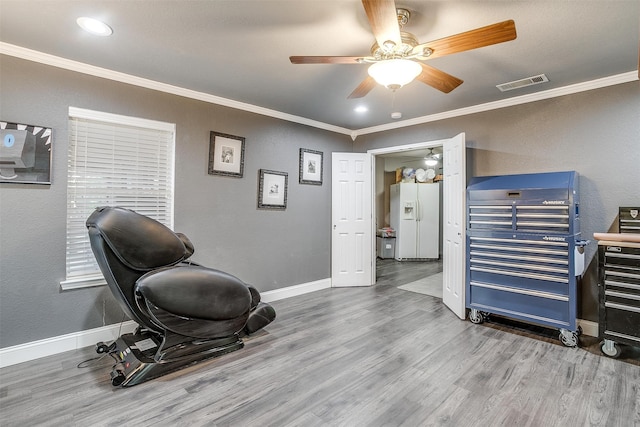 exercise area featuring hardwood / wood-style flooring, ceiling fan, and ornamental molding