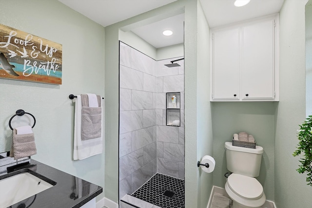 bathroom with toilet, sink, and a tile shower