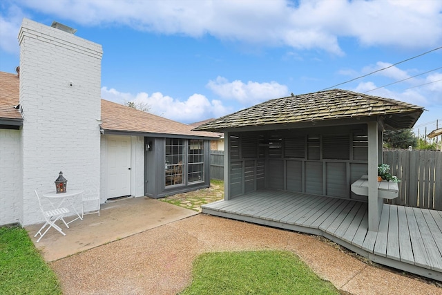 rear view of property featuring a deck and a patio area