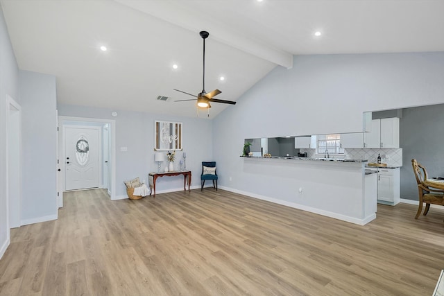 unfurnished living room with beamed ceiling, ceiling fan, light hardwood / wood-style flooring, and high vaulted ceiling