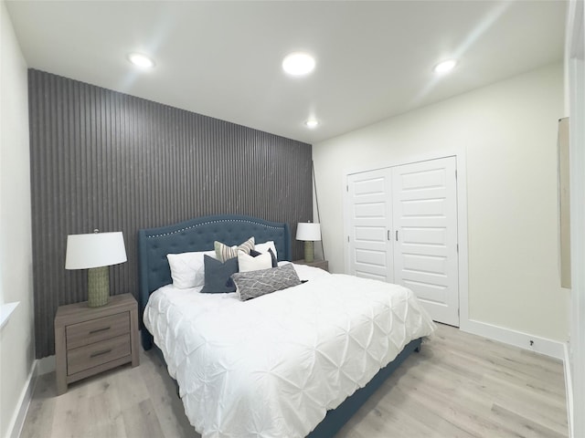 bedroom with light hardwood / wood-style flooring and a closet