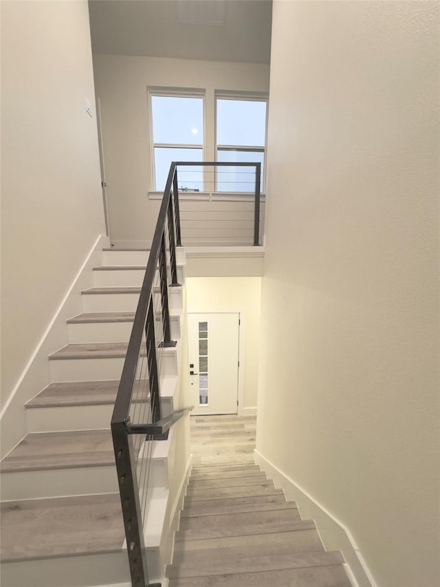 stairway featuring hardwood / wood-style floors and a high ceiling