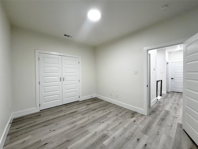 unfurnished bedroom featuring light hardwood / wood-style floors and a closet