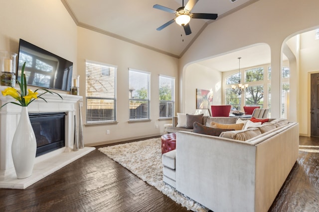 living room with vaulted ceiling, dark wood-type flooring, ceiling fan with notable chandelier, and ornamental molding