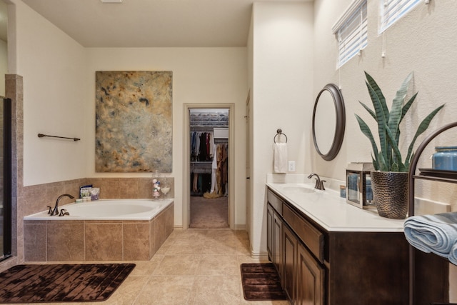 bathroom featuring vanity, tile patterned floors, and tiled tub