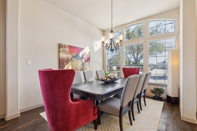 dining space featuring dark hardwood / wood-style floors, a wealth of natural light, and an inviting chandelier