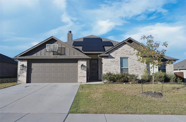 view of front of property featuring a garage, solar panels, and a front lawn