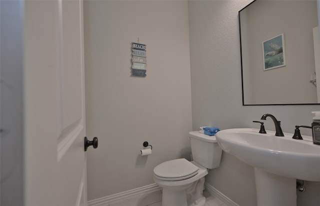 bathroom featuring tile patterned flooring, toilet, and sink