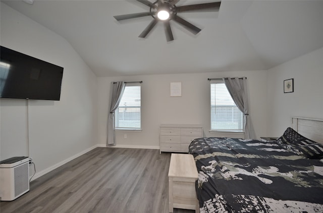 bedroom with ceiling fan, vaulted ceiling, and wood-type flooring