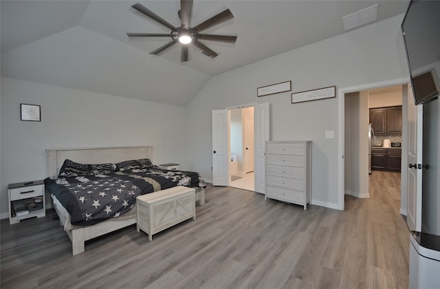 bedroom with ensuite bathroom, light hardwood / wood-style floors, ceiling fan, and vaulted ceiling