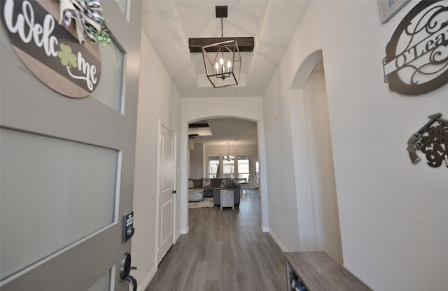 hall with a chandelier and wood-type flooring