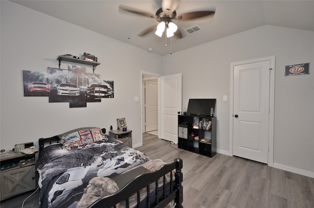 bedroom with ceiling fan, lofted ceiling, and wood-type flooring