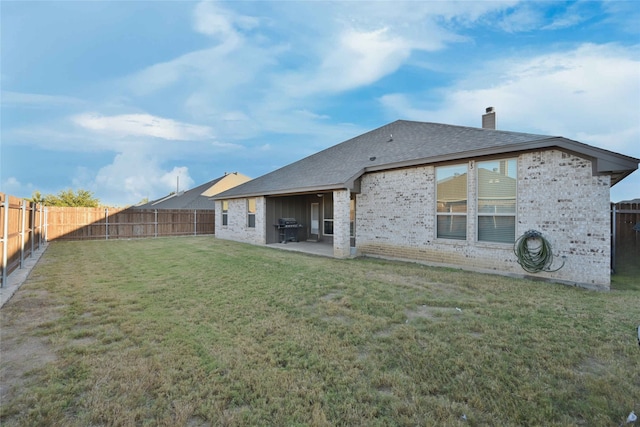 rear view of house with a lawn and a patio area