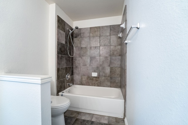 bathroom with tiled shower / bath combo and toilet