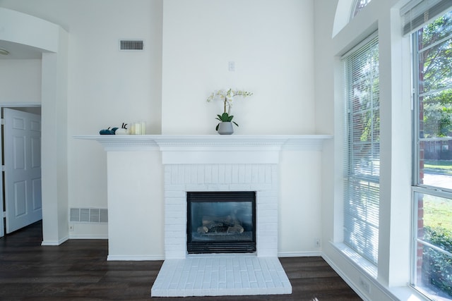 details with hardwood / wood-style floors and a brick fireplace