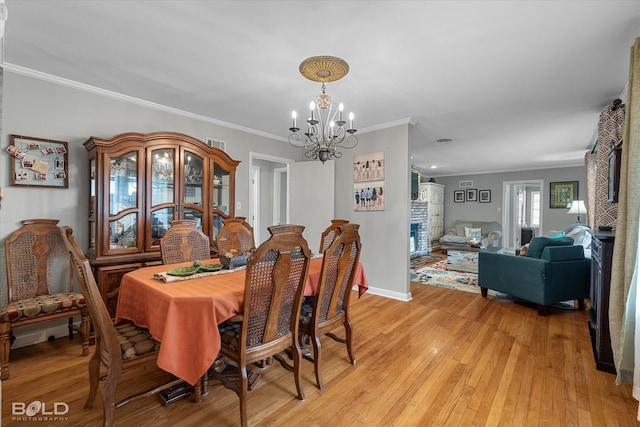 dining area featuring a chandelier, light hardwood / wood-style flooring, and crown molding