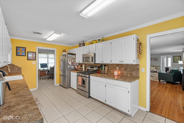 kitchen with sink, white cabinetry, stainless steel appliances, and a wealth of natural light