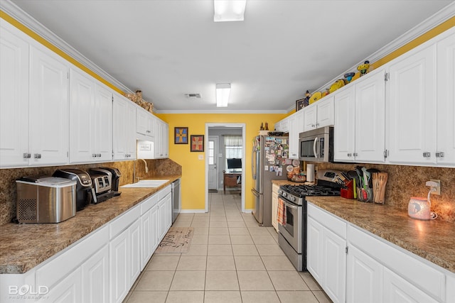 kitchen with white cabinets, appliances with stainless steel finishes, crown molding, and sink