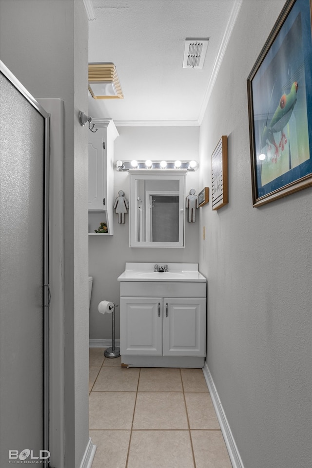 bathroom featuring tile patterned floors, crown molding, toilet, a shower with door, and vanity