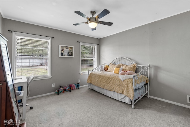 carpeted bedroom featuring ceiling fan and crown molding