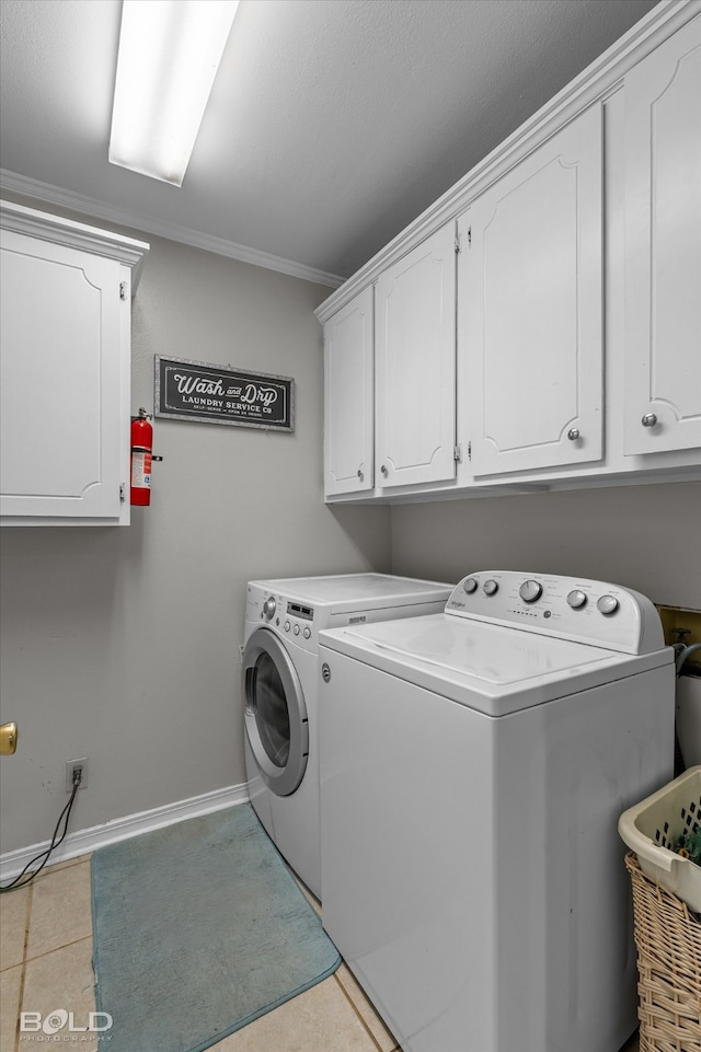 clothes washing area featuring cabinets, separate washer and dryer, crown molding, and light tile patterned flooring