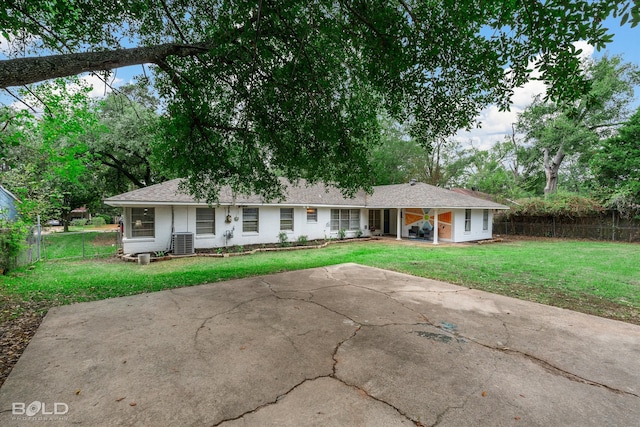 ranch-style house with a front yard and central AC unit