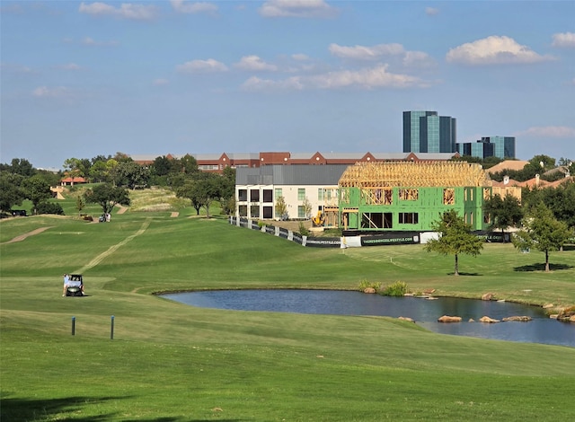 view of property's community featuring a yard, golf course view, and a water view