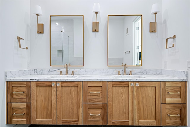 bathroom featuring double vanity, a sink, and a shower with door