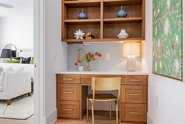 home office with light wood finished floors and built in desk