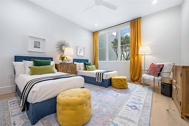 bedroom with lofted ceiling, ceiling fan, light wood finished floors, and baseboards