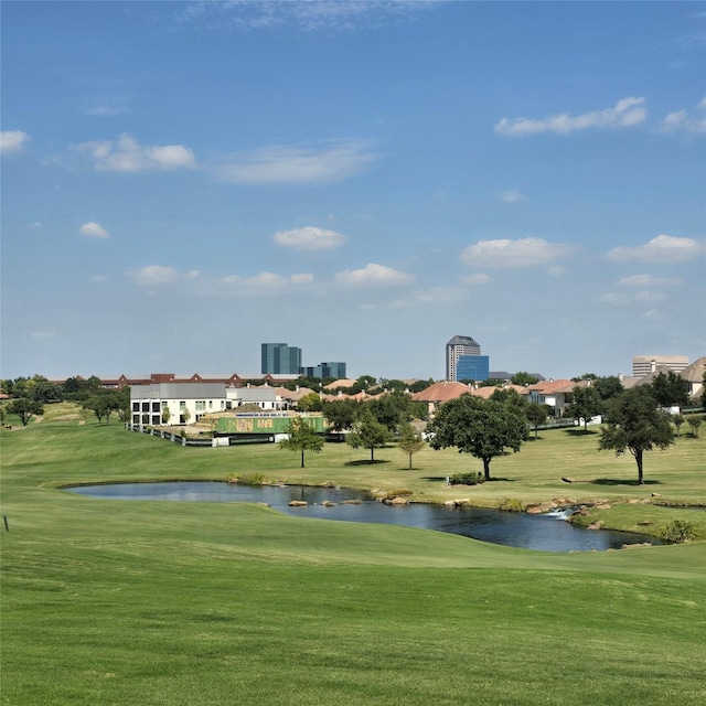 view of home's community with a water view, a yard, and golf course view