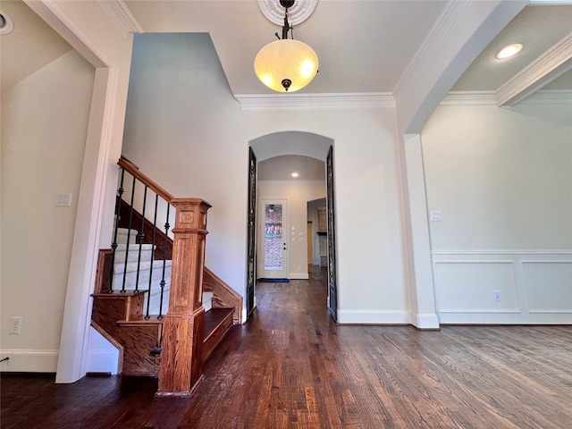 foyer with crown molding and dark wood-type flooring