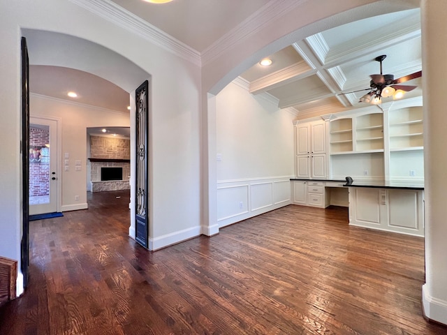 interior space featuring built in desk, dark hardwood / wood-style floors, coffered ceiling, and ornamental molding