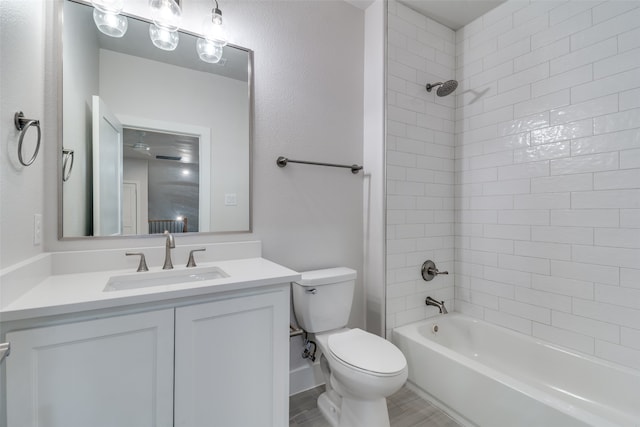 full bathroom with vanity, tiled shower / bath combo, and toilet