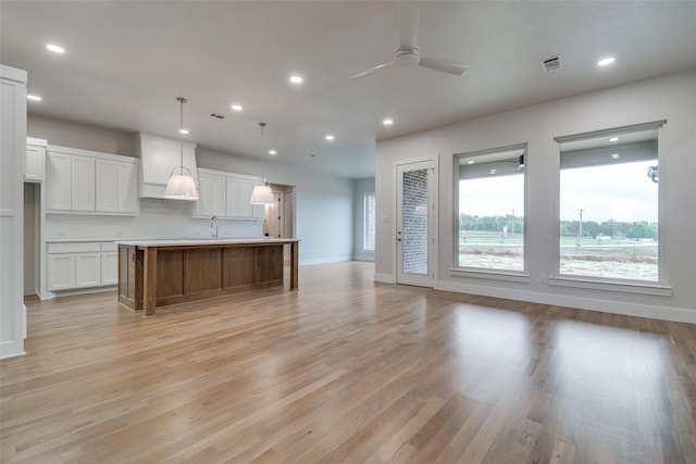 9813 Aiken Ct, Mesquite, TX 75126 - kitchen with ceiling fan, recessed lighting, white cabinetry, light wood-style flooring, and a spacious island